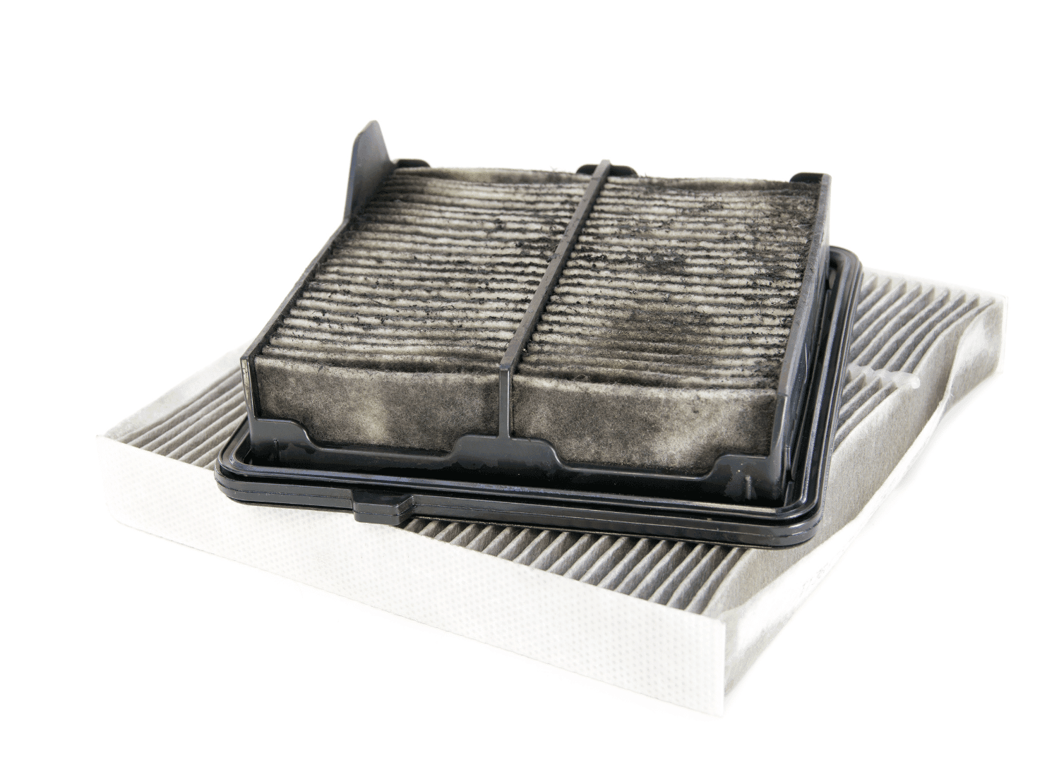 A dirty, used car cabin air filter sits atop a clean, new filter against a white surface. The old filter looks dark and dusty, while the new one is light gray—highlighting the importance of regular auto maintenance.